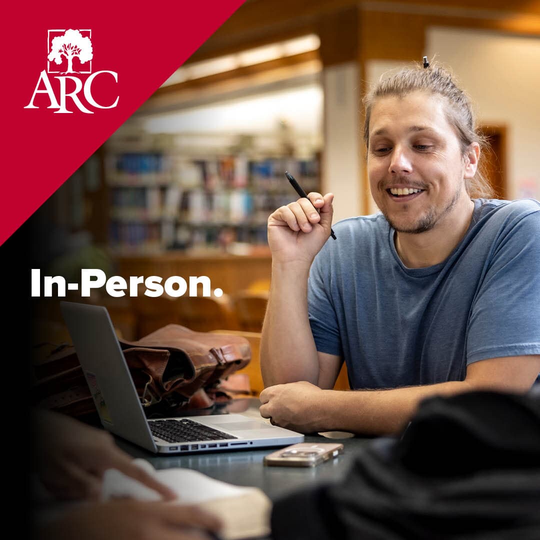 Text over photo of smiling man sitting at a desk that says In Person next to ARC logo